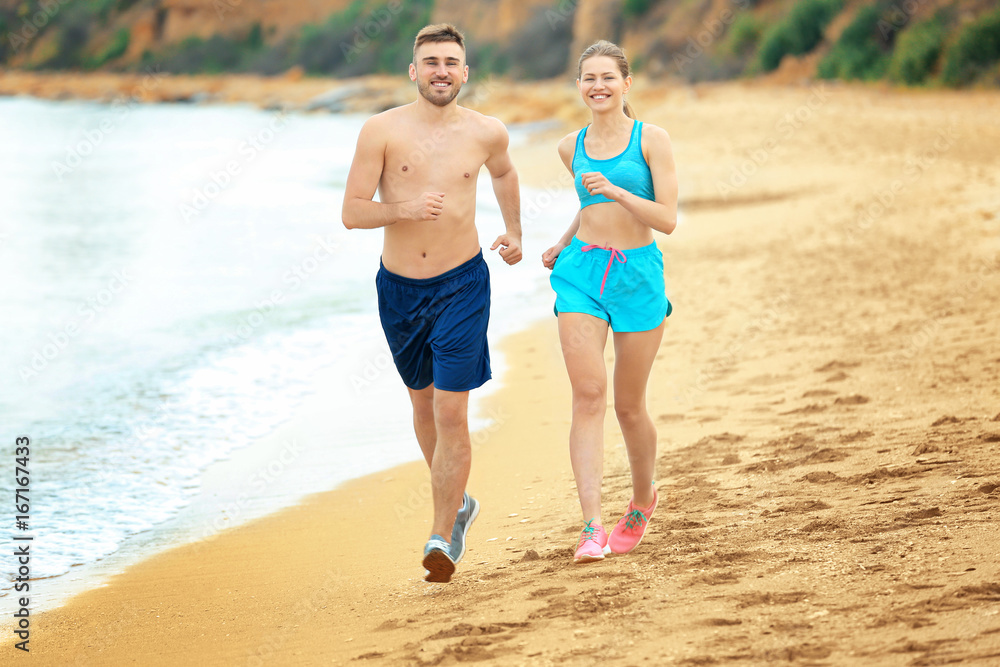 Young couple running on seashore Young couple running on seashore