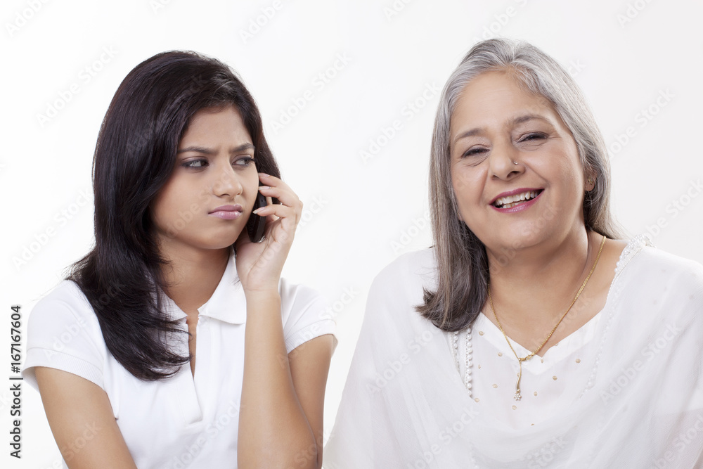 Irritated girl looking at her grandmother Irritated girl looking at her grandmother