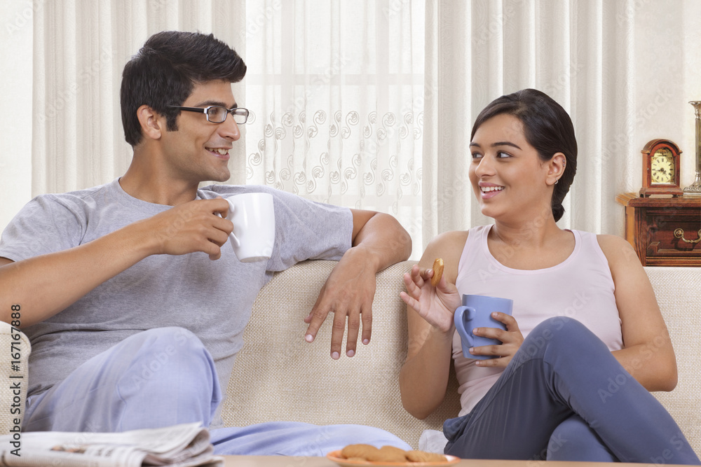 Young couple talking while having coffee 
