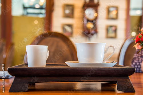 A cup of coffee on the wooden table.