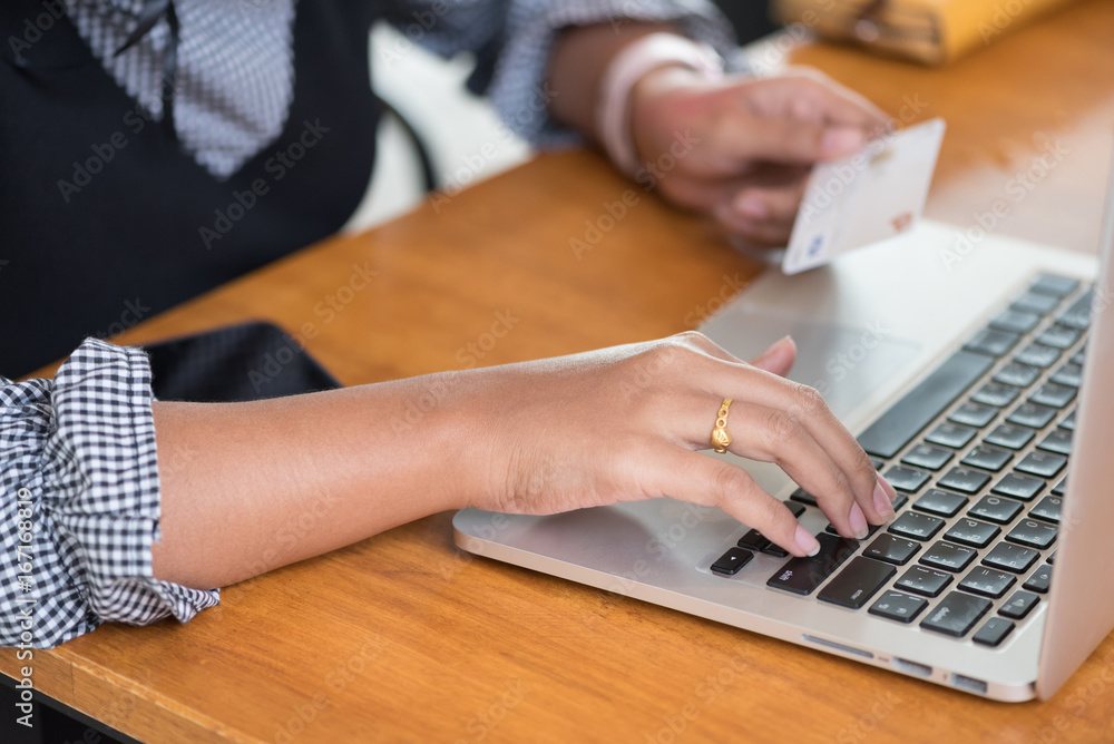 Asian woman using credit card shopping online with computer laptop in selective focus. Asian woman using credit card shopping online with computer laptop in selective focus.
