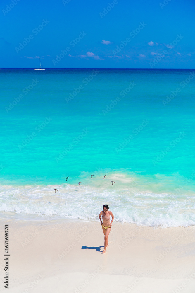 Young beautiful girl on the beach at shallow tropical water top view