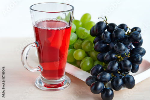 A glass of grape juice and juicy grape