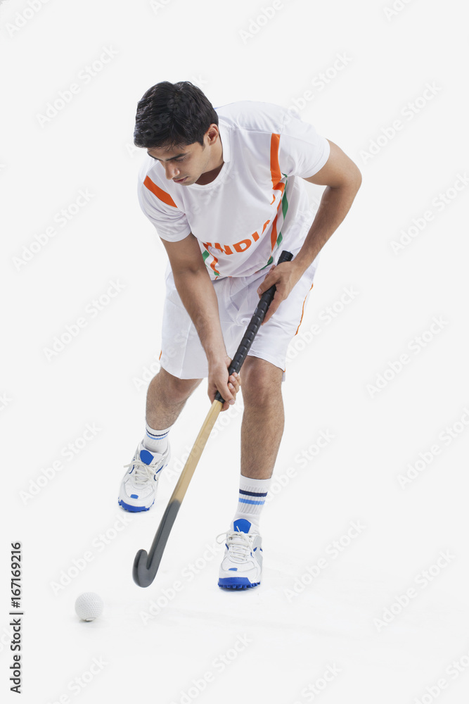 Full length of young man playing field hockey isolated over white background Full length of young man playing field hockey isolated over white background