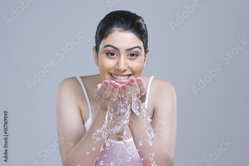 Portrait of beautiful woman washing over gray background