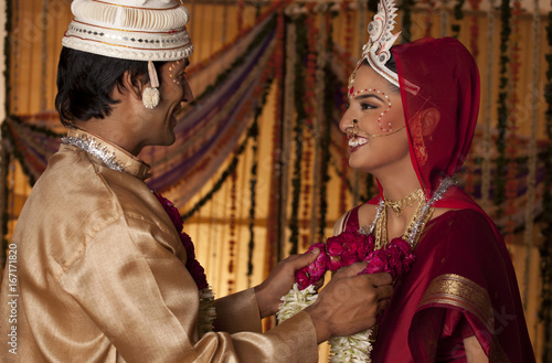 Bengali groom putting a garland on a bride  photo