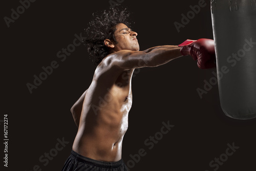 Boxer hitting punching bag aggressively 