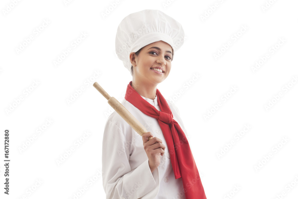 Portrait of young female chef holding rolling pin isolated over white background Portrait of young female chef holding rolling pin isolated over white background