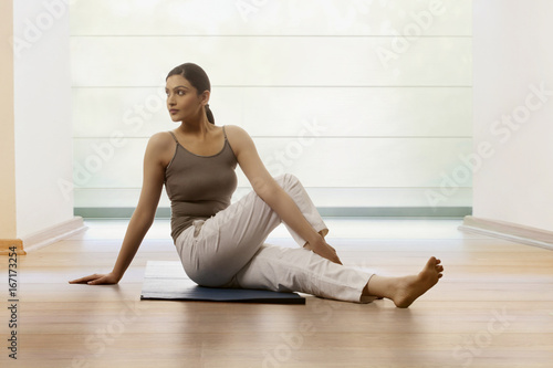 Woman doing stretching exercise on yoga mat