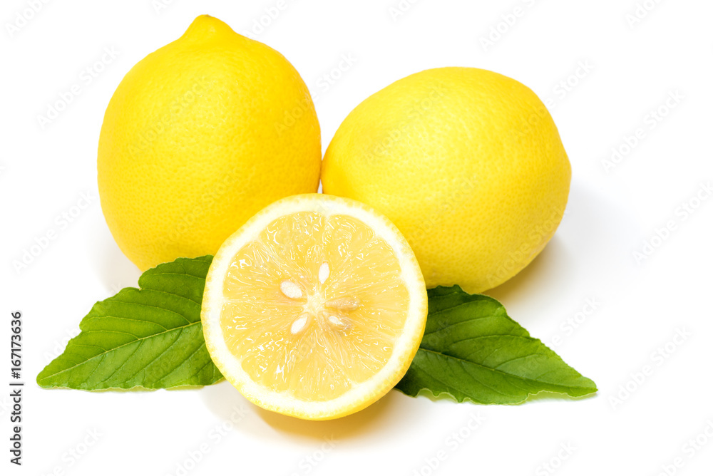 close up of lemons cut in half with green leaves on a white background