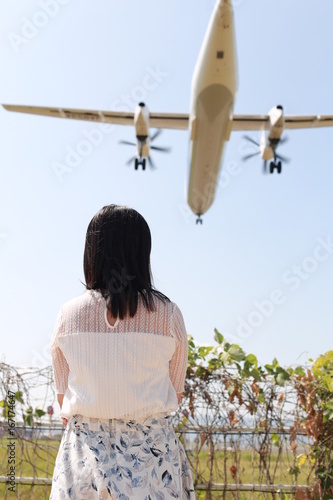 飛行機を眺める女性