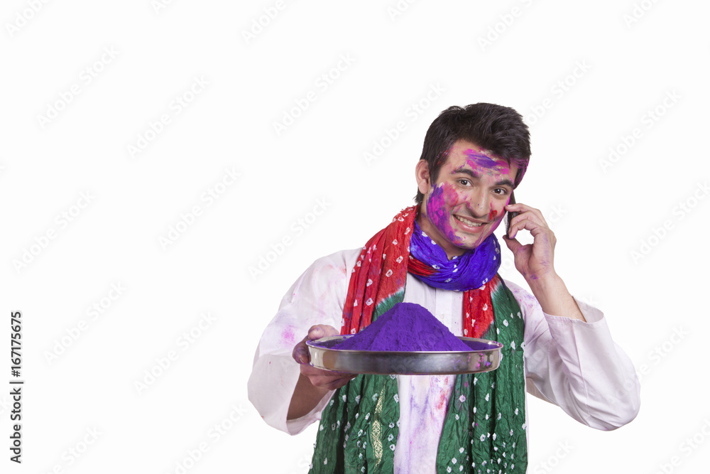 Portrait of a man with holi colour talking on a mobile phone Portrait of a man with holi colour talking on a mobile phone