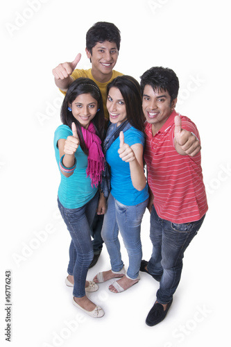 High angle portrait of college students gesturing thumbs up against white background