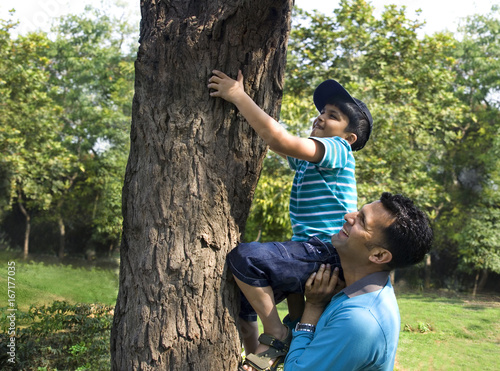 Father helping his son climb a tree  © IndiaPix