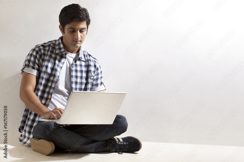 Young man sitting on floor with laptop Young man sitting on floor with laptop