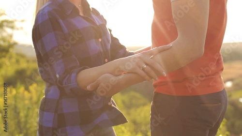 Close-up of the hands loving couple outdoors at sunset. photo