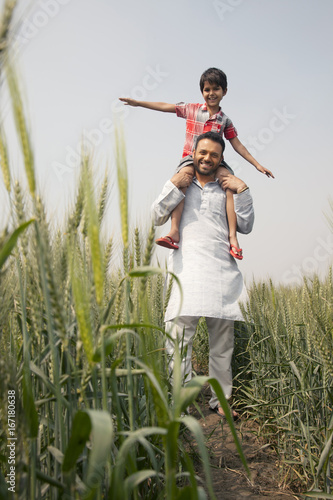 Low angle view of a happy father carrying son on shoulders 