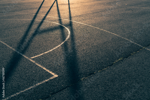 Close-up of a basketball court with golden back light and shadow © Jamo Images