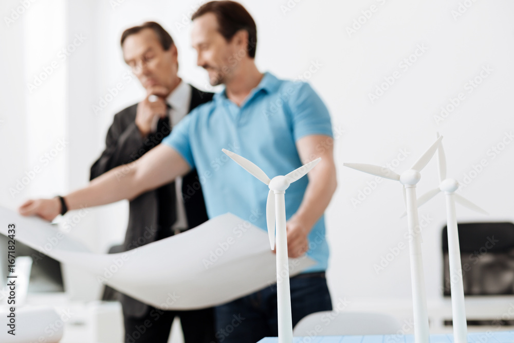 Fototapeta premium Young engineer showing a blueprint to his boss