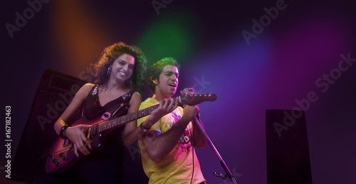 Man singing while a woman plays the guitar 