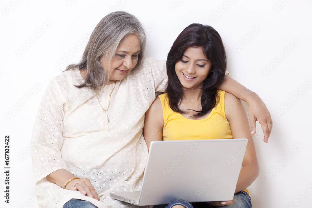 Teenage girl and grandmother using laptop Teenage girl and grandmother using laptop