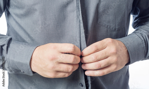 Fotografija Men putting on his shirt close up