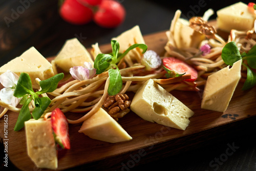 Pieces of cheese on a board with vegetables hd