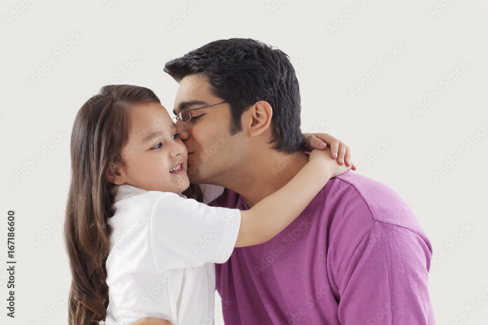 Obraz premium Father kissing daughter on cheeks 