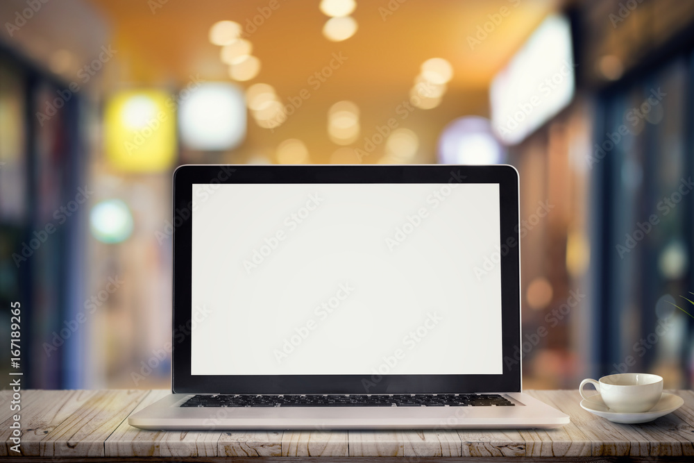 Laptop on table against bokeh lights background, blank screen for graphic display montage. Laptop on table against bokeh lights background, blank screen for graphic display montage.