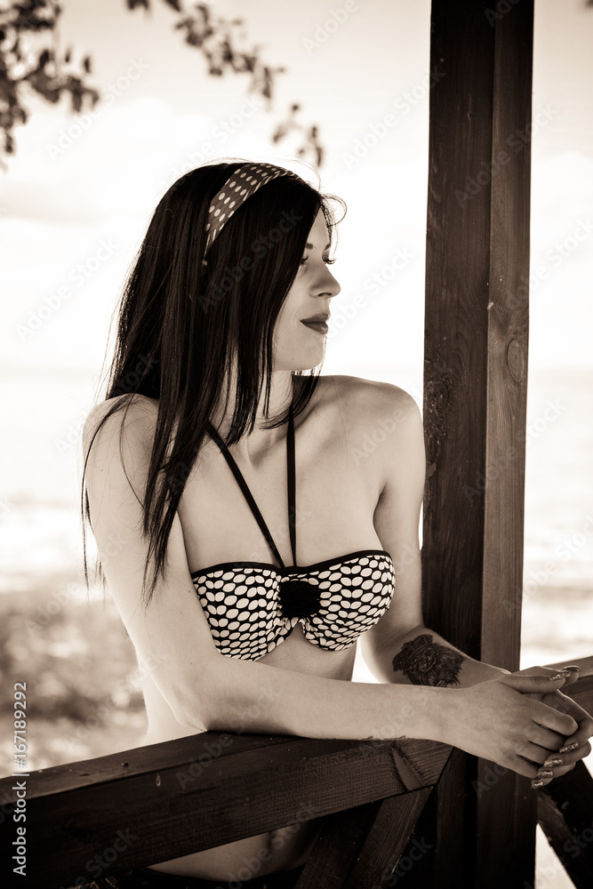 Beautiful beach babe portrait, happy summer girl in 50s swimsuit on the  beach, attractive young woman