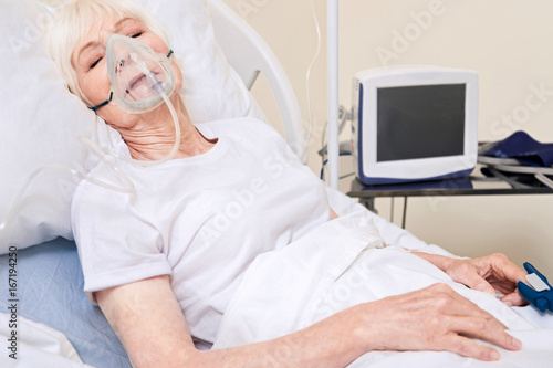 Unconscious unstable lady wearing equipment for sustainable breathing