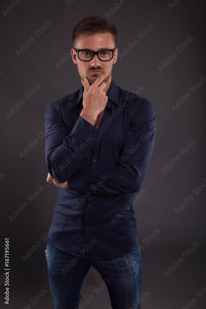 Young sexy man portrait of a confident businessman showing by hands on a black background. Ideal for banners, registration forms, presentation, landings, presenting concept. Young sexy man portrait of a confident businessman showing by hands on a black background. Ideal for banners, registration forms, presentation, landings, presenting concept.