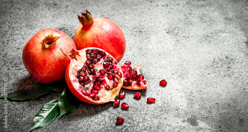 Fresh pomegranates with green leaves.