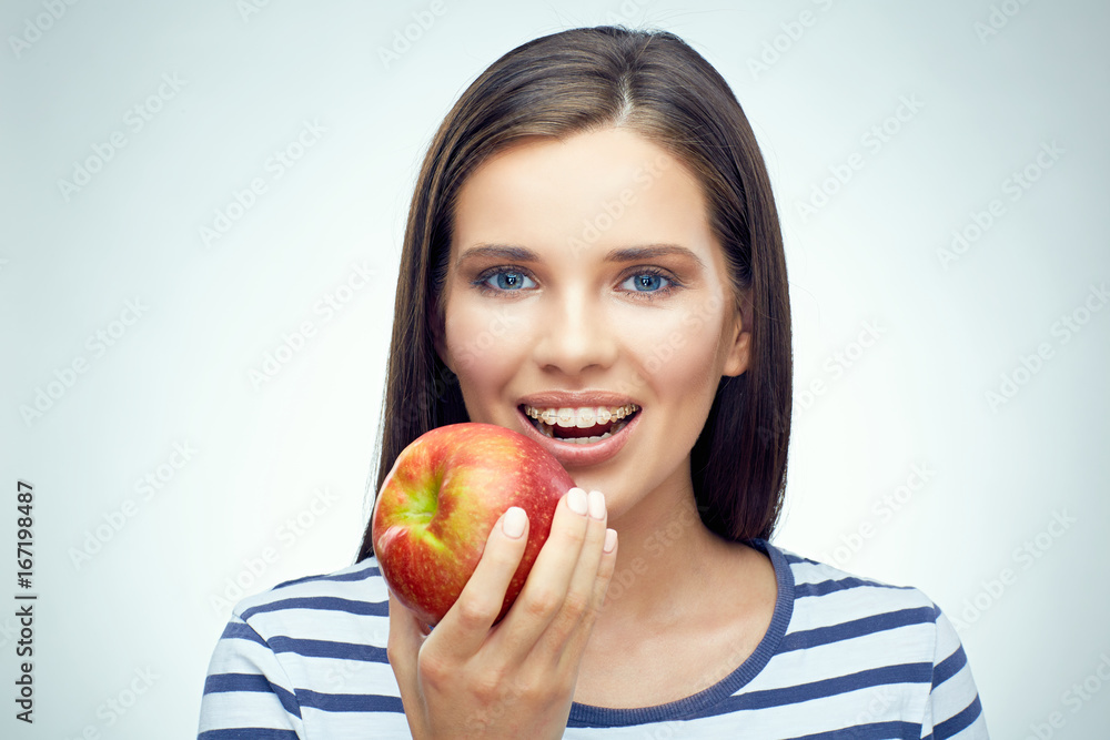 Smiling girl with dental braces holding red apple. Smiling girl with dental braces holding red apple.
