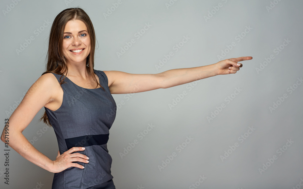 Smiling business woman pointing finger at gray Smiling business woman pointing finger at gray