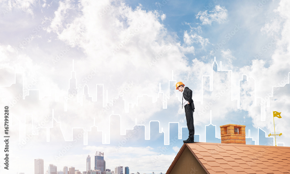Engineer man standing on roof and looking down. Mixed media Engineer man standing on roof and looking down. Mixed media