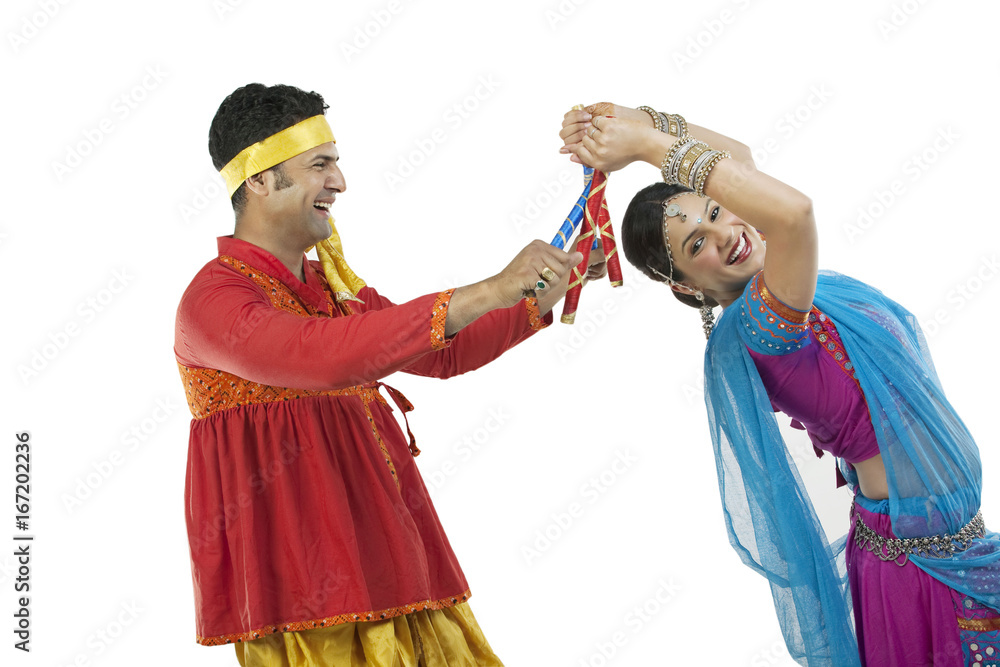 Gujarati couple performing dandiya dance 