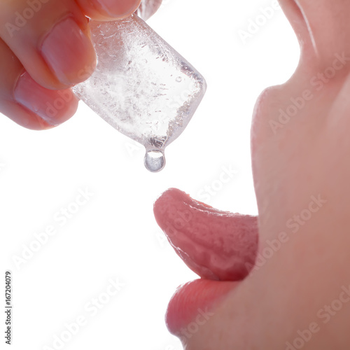 close-up macro girl holding piece of ice by fingers and trying to catch water drop by her tongue