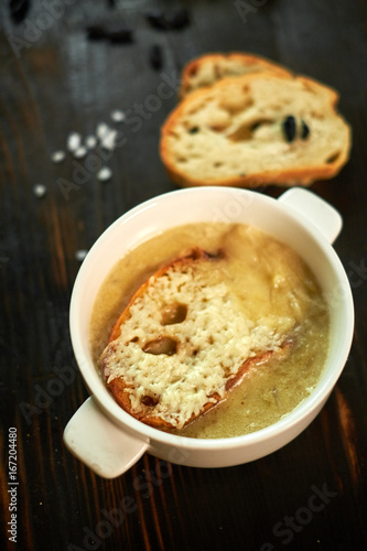 Broth with toasts of bread and black olives