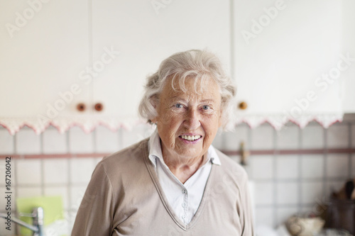 Smiling elderly woman in kitchen photo