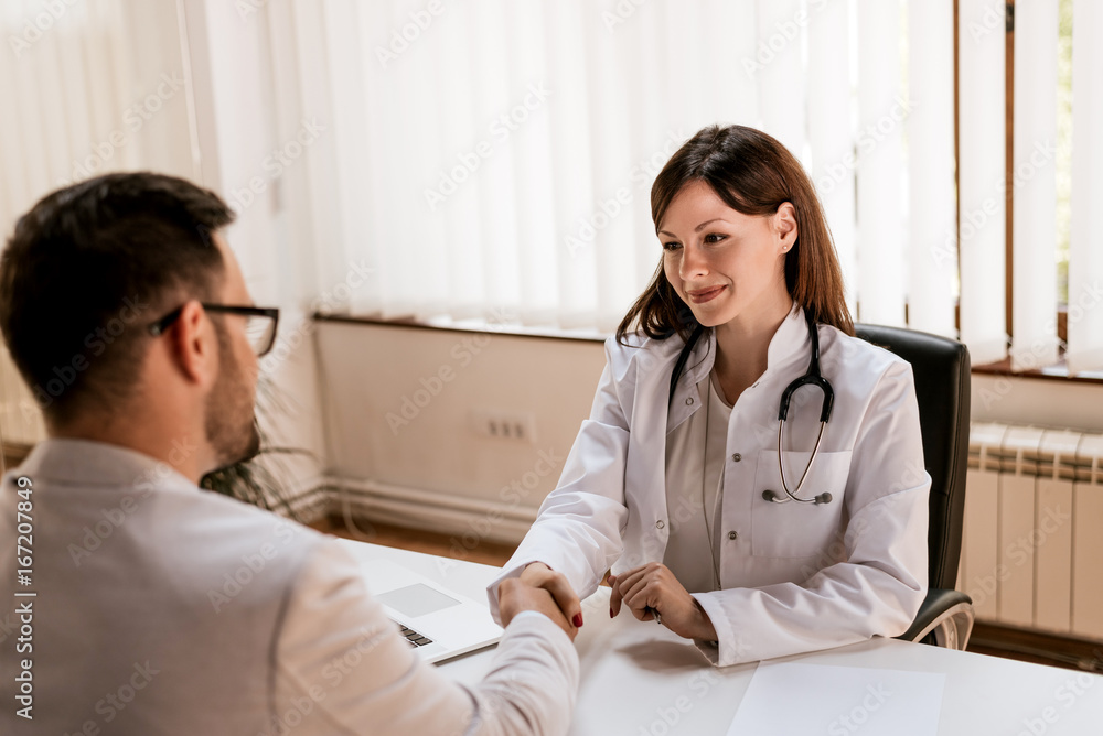 Fototapeta premium Doctor shaking hands to the male patient in the office