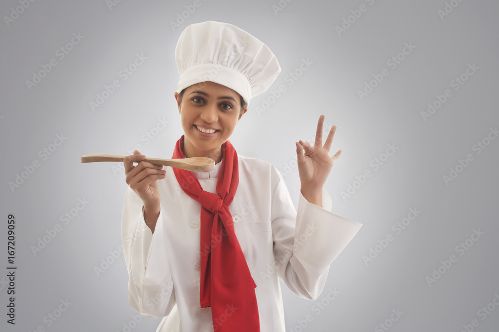 Portrait of young female chef gesturing ok sign Portrait of young female chef gesturing ok sign