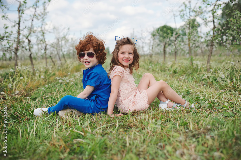 little boy and girl in blooming garden little boy and girl in blooming garden