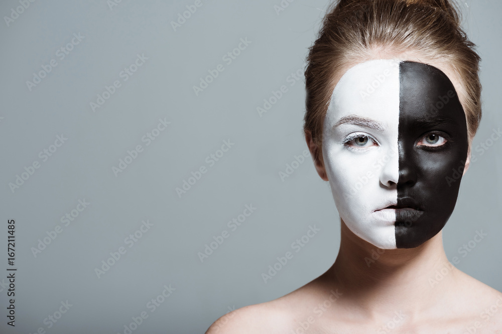 young beautiful girl with creative white and black bodyart on face looking at camera, isolated on grey young beautiful girl with creative white and black bodyart on face looking at camera, isolated on grey