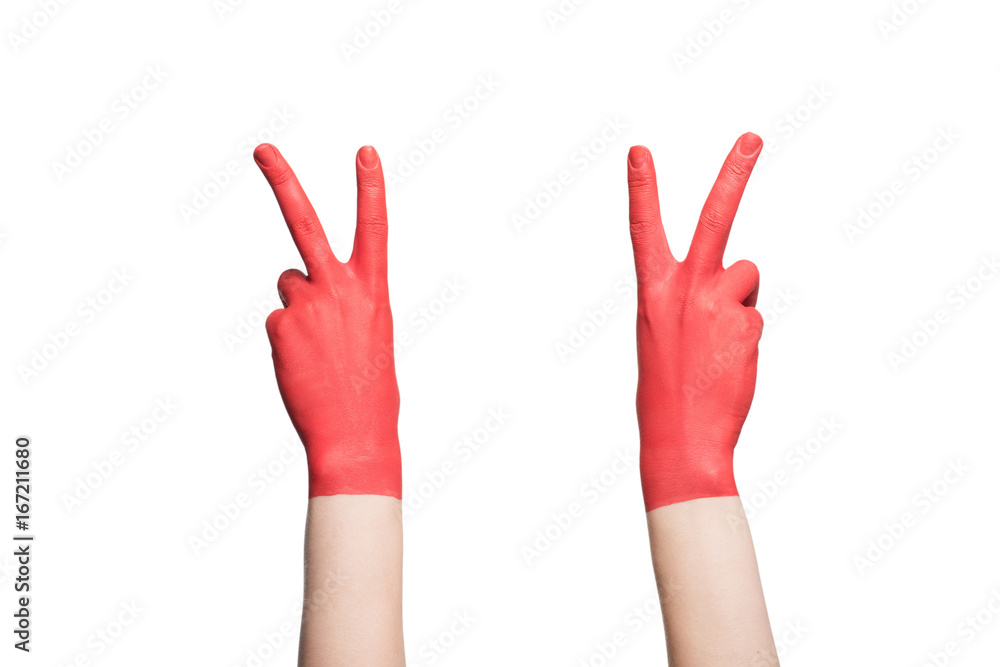 Obraz premium cropped view of hands in red paint showing victory signs, isolated on white
