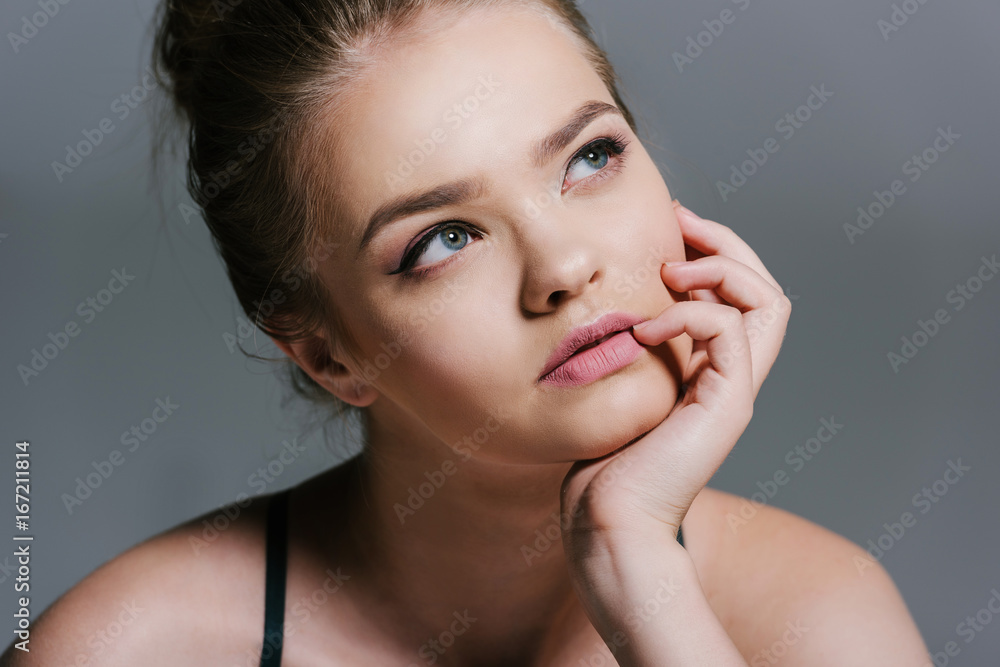 portrait of beautiful thoughtful teen girl looking away on grey portrait of beautiful thoughtful teen girl looking away on grey