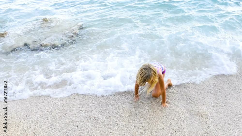 The legs of children playing in the sea. Standing on pebble beach and waiting for waves. Concept for summer beach vacation The legs of children playing in the sea. Standing on pebble beach and waiting for waves. Concept for summer beach vacation