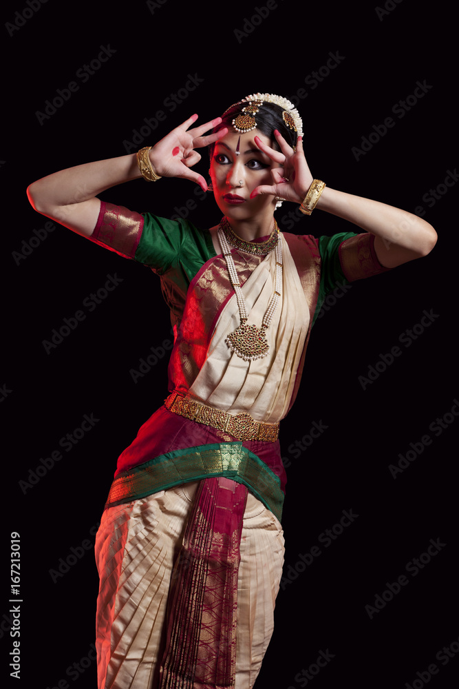 Fototapeta premium Furious Bharatanatyam dancer performing over black background