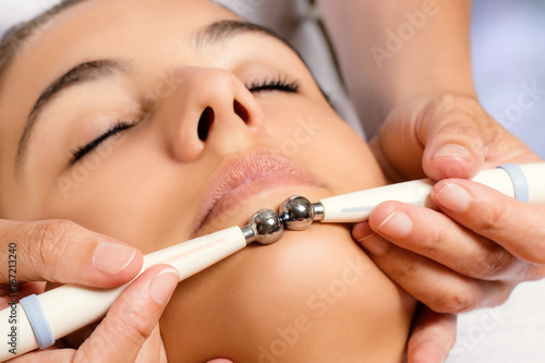 Foto Therapist applying low frequency galvanic electrodes on face.