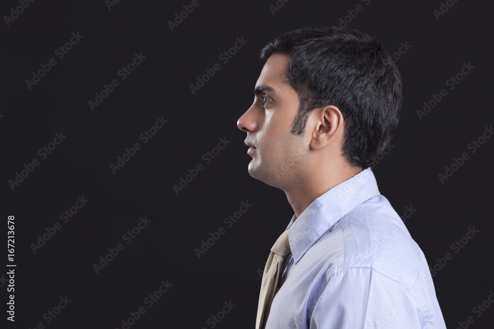 Obraz premium Profile shot of businessman against black background